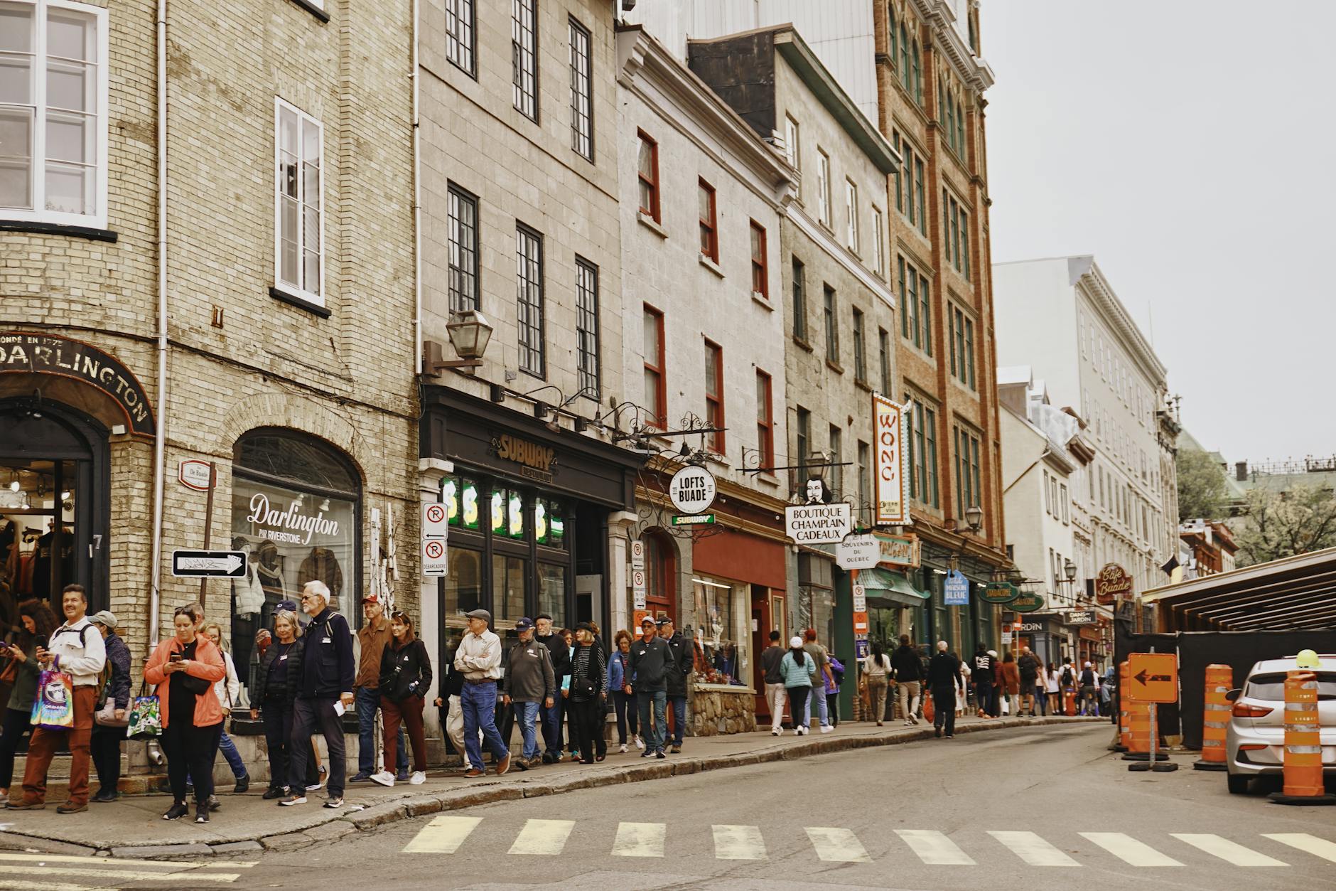 Ruchliwa historyczna ulica z kamienicami i spacerującymi ludźmi