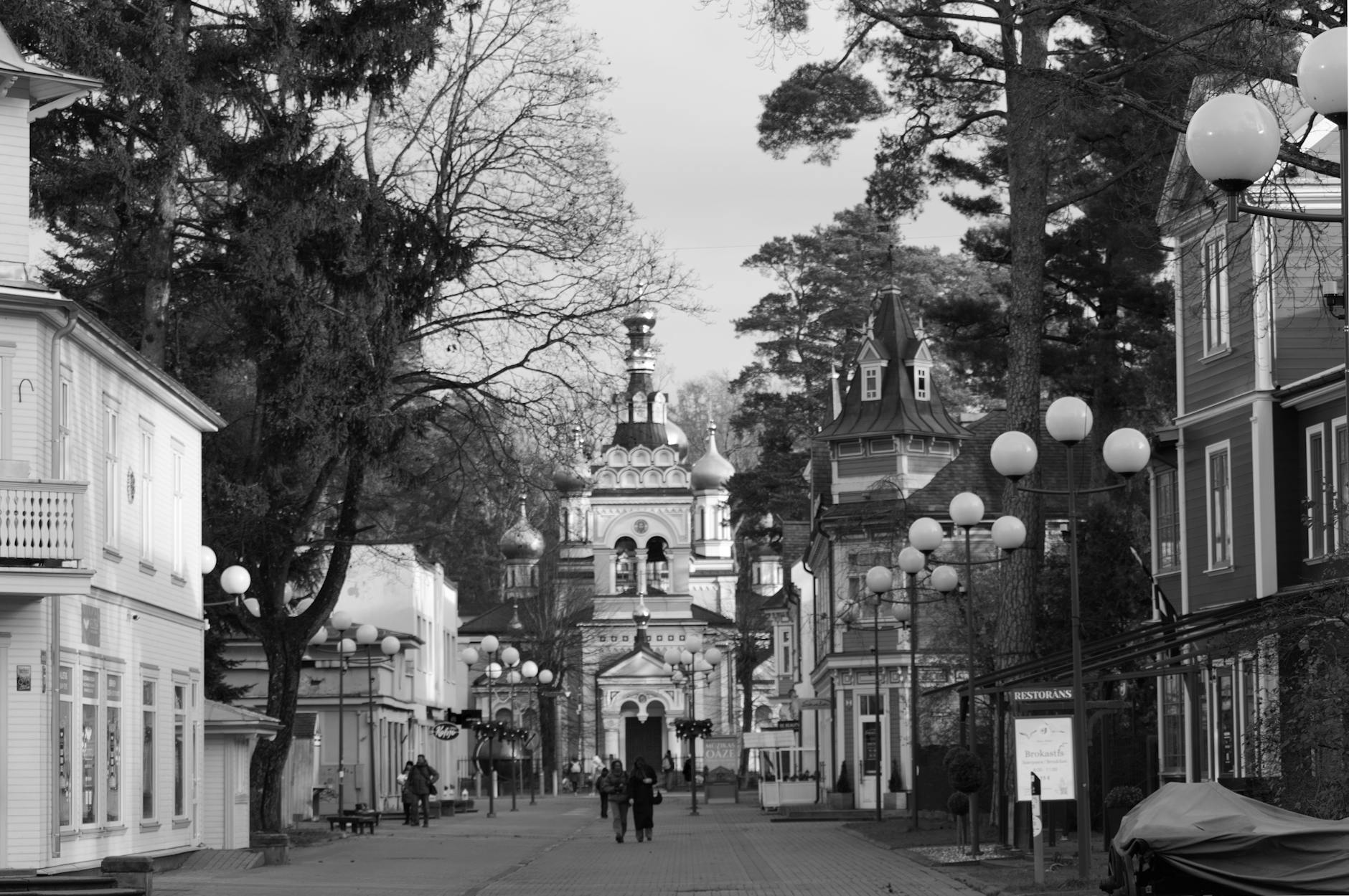 Czarno-biała ulica Ciechanowa z kościołem farnym i latarniami