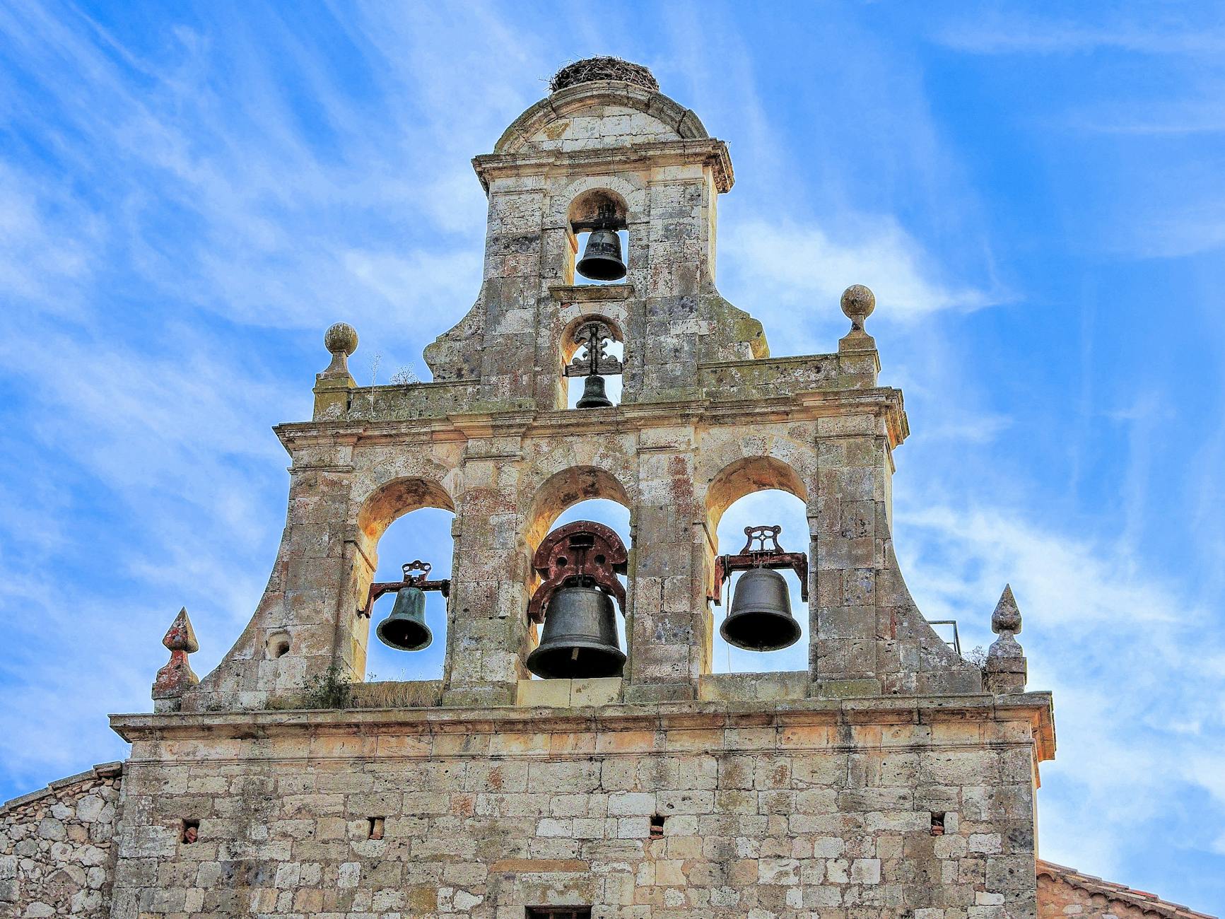 Gotycka dzwonnica na tle błękitnego nieba, kamienna sakralna architektura