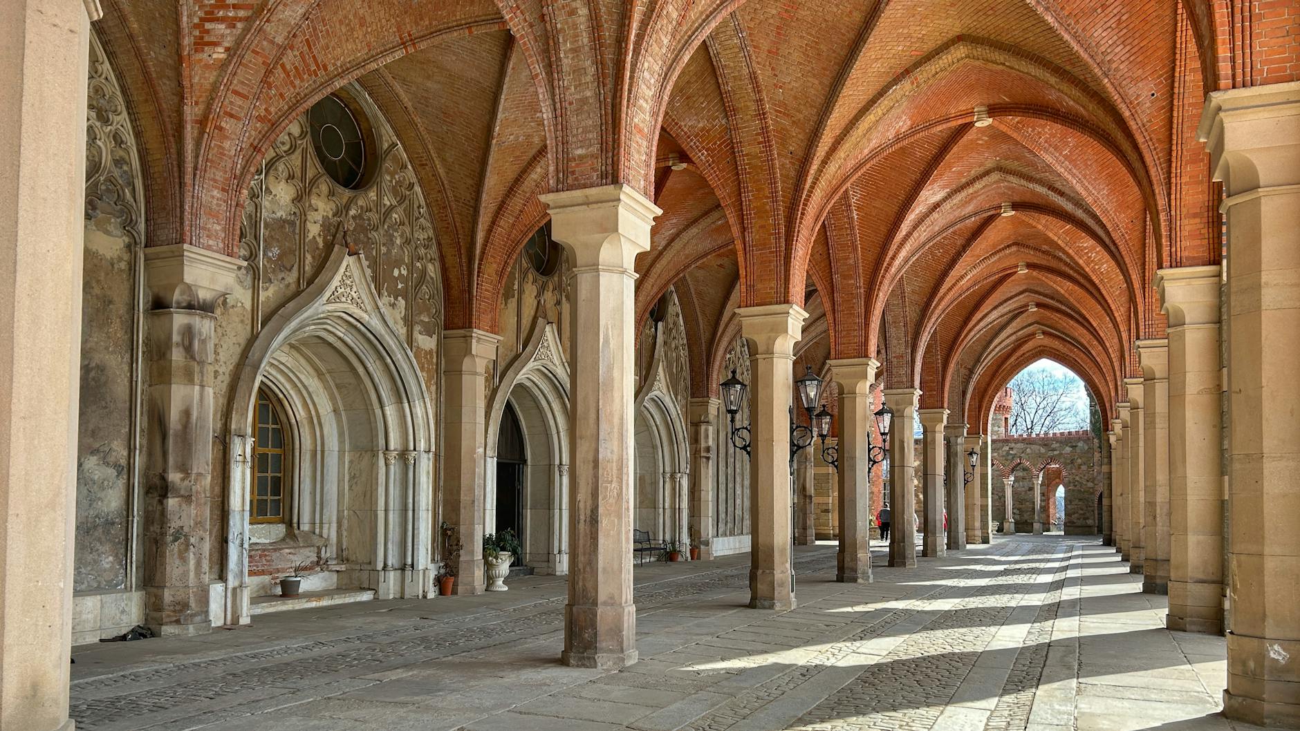 Ceglany gotycki krużganek z arkadami w pałacu Kamieniec Ząbkowicki