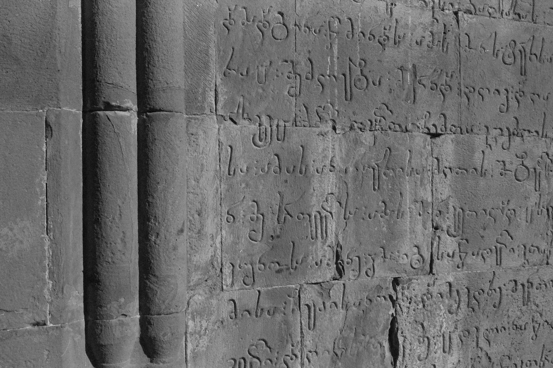 Zbliżenie na kamienną tablicę z wyrytymi łacińskimi inskrypcjami