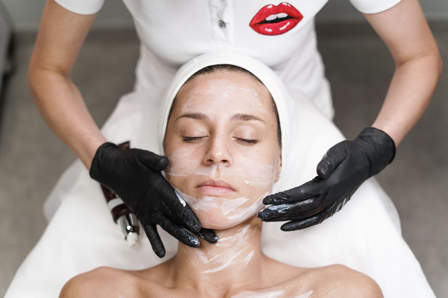 Kobieta w spa podczas zabiegu oczyszczającego twarz z maską